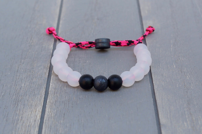 Translucent adjustable silicone bead bracelet on pink and black paracord